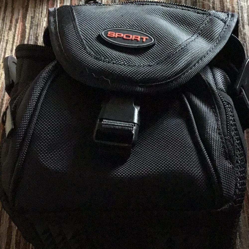 Black sport camera bag with no strap 5 inches tall a lot of compartments